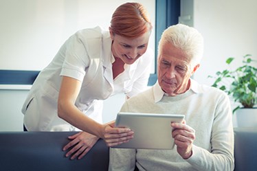 Nurse showing man something on at tablet